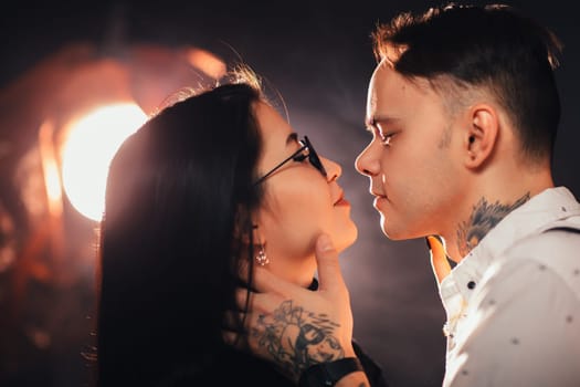 portrait couple in fashionable clothes on a dark smoky background.