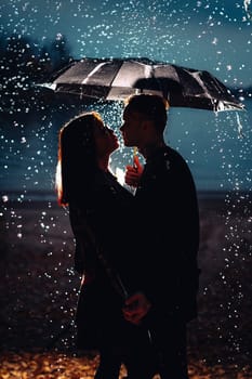 young man and woman under an umbrella and rain.