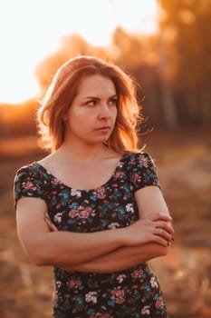 portrait of a beautiful girl in a field on a sunset background.