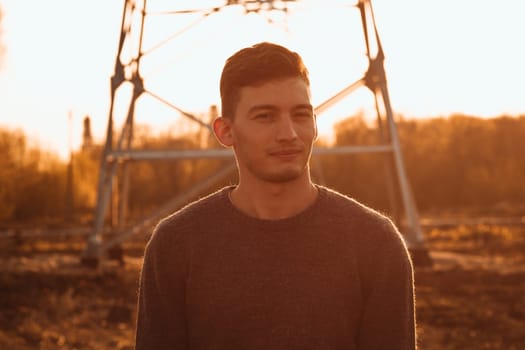 portrait of a guy in the field on a sunset background.