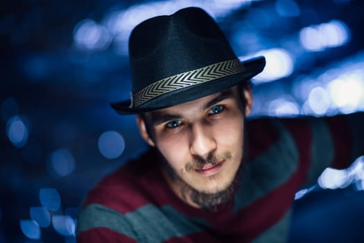 portrait of a guy in a hat on a blurred background.