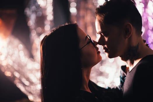 Couple in fashionable clothes on a shiny background.