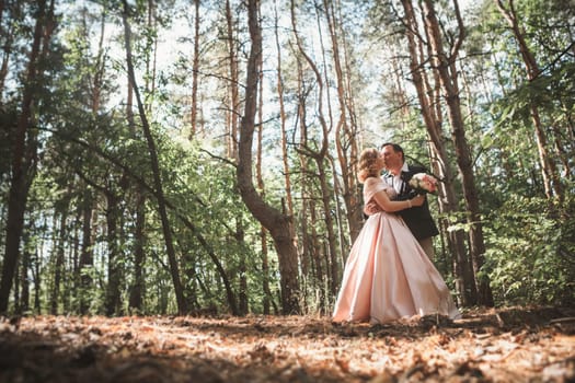 bride and groom on the background of trees and woods in full growth.