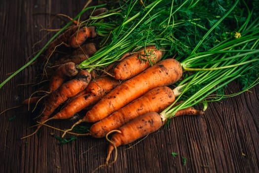 Fresh carrots close-up on a wooden background.