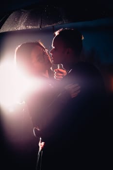 young man and woman under an umbrella and rain.