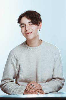 portrait of a teenager brunette guy in a studio.