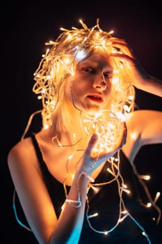 portrait of a girl with a garland on black background.