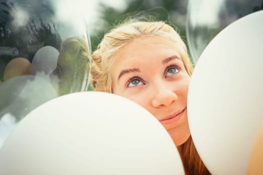 portrait of young girl with balloons on nature background.