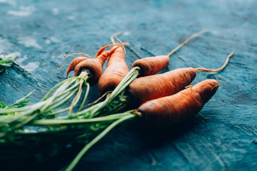 Fresh carrots on a blue wooden background.