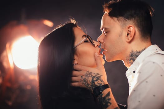 portrait couple in fashionable clothes on a dark smoky background.