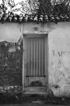 Rusty door and textured wall. Abandoned house exterior.