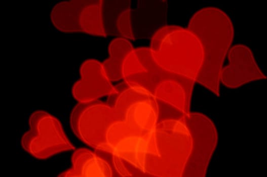 Romantic red hearts on black background. Abstract love background.