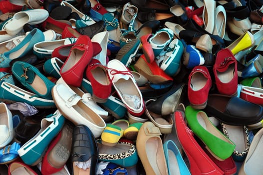 Shoes for sale at street market. Pile of assorted footwear abstract background.