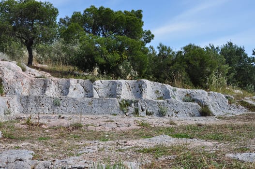 Eptathronon seven thrones plateau ancient greek ruins on philopappos hill. Rock hewn seats remains of a public square or assembly court.