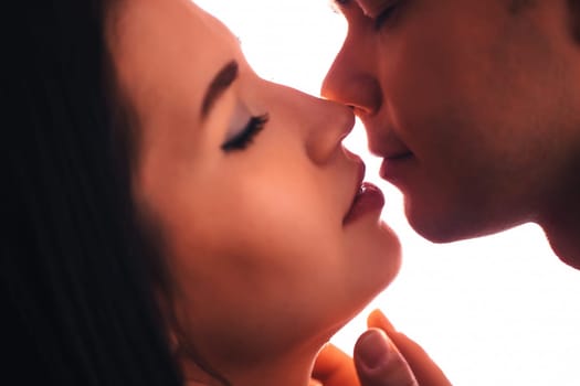 guy and the girl kiss closeup on a light background