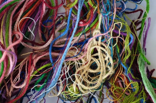 Tangled sewing threads closeup abstract colorful background.