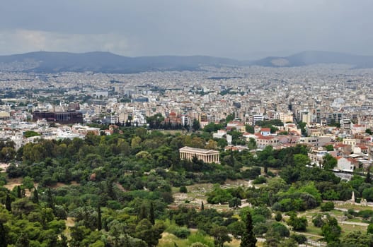 ATHENS, GREECE - MAY 6, 2014: View of the ancient agora with the temple of Hephaestus standing in contrast to the modern buildings of the city of Athens, Greece.