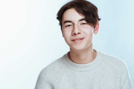 portrait of a teenager brunette guy in a studio.