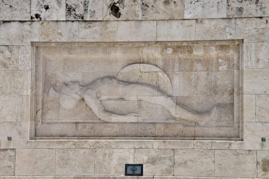 Tomb of the unknown soldier marble sculpture of dying ancient greek hoplite warrior holding his shield and spear, Athens Greece.