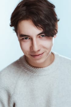 portrait of a teenager brunette guy in a studio.