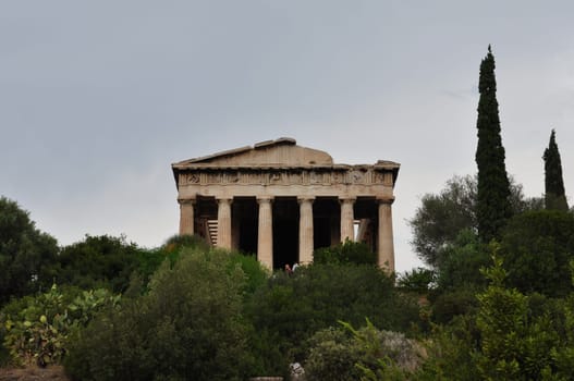 ATHENS, GREECE - SEPTEMBER 2, 2014: People visiting temple of hephaestus and lush vegetation at the ancient agora.