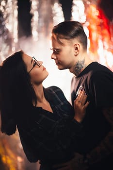 Couple in fashionable clothes on a shiny background.