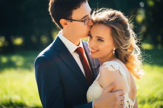 bride and groom embracing on nature background.