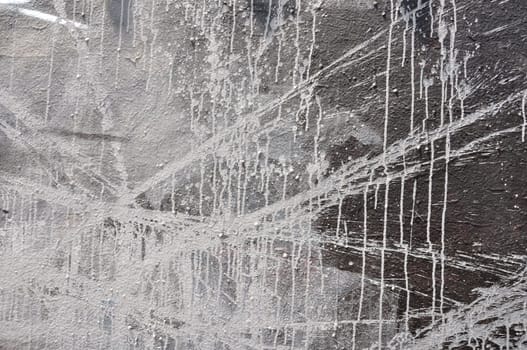 White paint smudged over black wall. Abstract background.