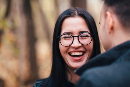 portrait of a young woman and a man walking in the autumn forest.
