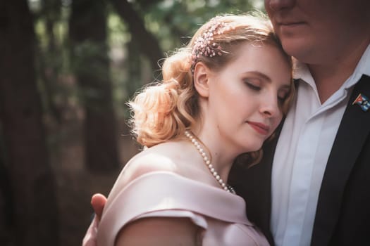 bride and groom on the background of trees and forest sun.