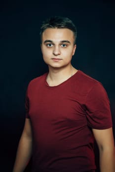 portrait of a young man on a dark background.