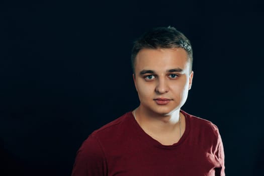 portrait of a young man on a dark background.