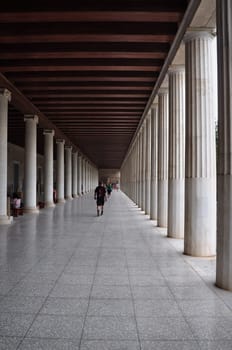 ATHENS, GREECE - SEPTEMBER 2, 2014: People visiting stoa of attalos covered walkway with ionic and doric columns in the ancient agora.
