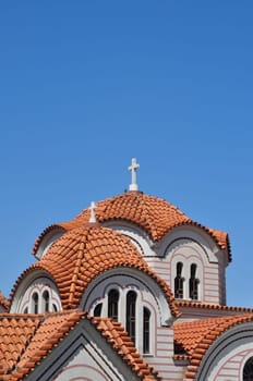 Orthodox church exterior detail of dome with cross and windows.