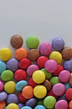 Colorful chocolate candy pieces on white background.