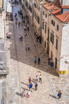 Dubrovnik, Croatia - April 2018 : Tourists walking on the main street between the old houses in Dubrovnik, viewed from the Old Town fortified walls