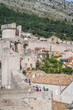 Dubrovnik, Croatia - April 2018 : Tourists walking on the massive and impressive walls of the fortified Old Town in Dubrovnik