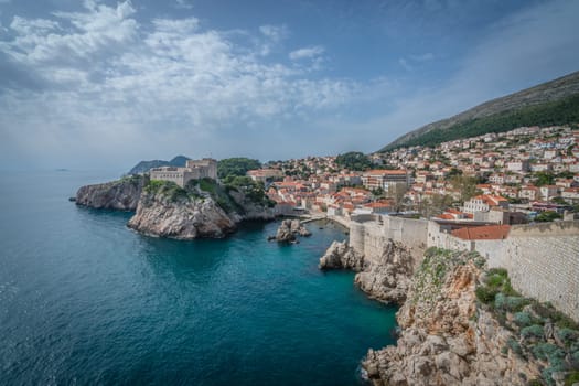 Dubrovnik, Croatia - April 2018 : Rocky coast alongside Dubrovnik Old Town massive defence walls of fortress Bokar