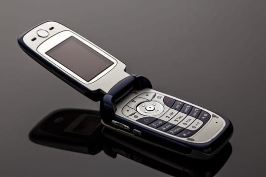 Old worn old-fashioned mobile phone on a gray background