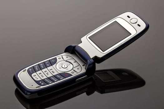Old worn old-fashioned mobile phone on a gray background