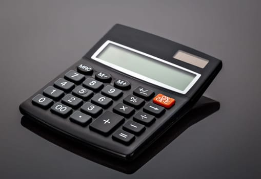 Old black old-style calculator on gray background