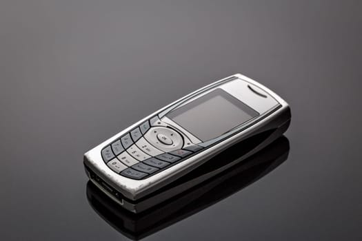 Old worn old-fashioned mobile phone on a gray background