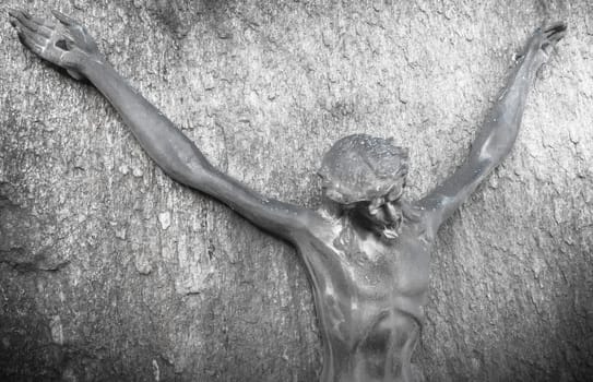 Bronze sculpture of Jesus Christ hanging on a rock wall. Ideal for easter concepts and other events.