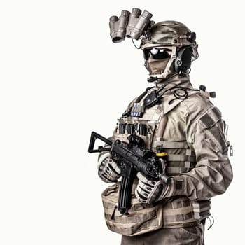 Army elite soldier with hidden behind mask and glasses face, in full tactical ammunition, equipped night vision device, radio headset, armed short barrel service rifle studio shoot on white background