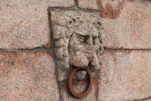 granite bas-relief of a lion's head on the quay