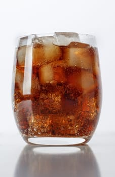 Fizzy drink with ice on a white table