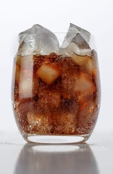 Fizzy drink with ice on a white table
