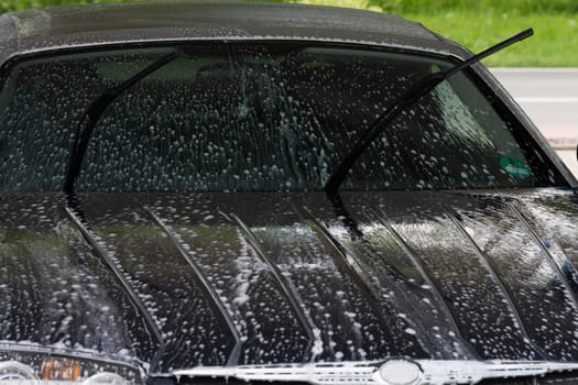 Manual car wash with pressurized water in the car wash outside.