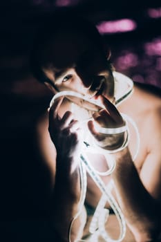 Portrait man Strip Light LED tape on dark color background.