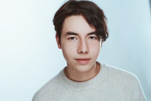 portrait of a teenager brunette guy in a studio.